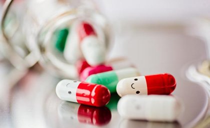 picture of pills in capsule form with happy faces drawn on them